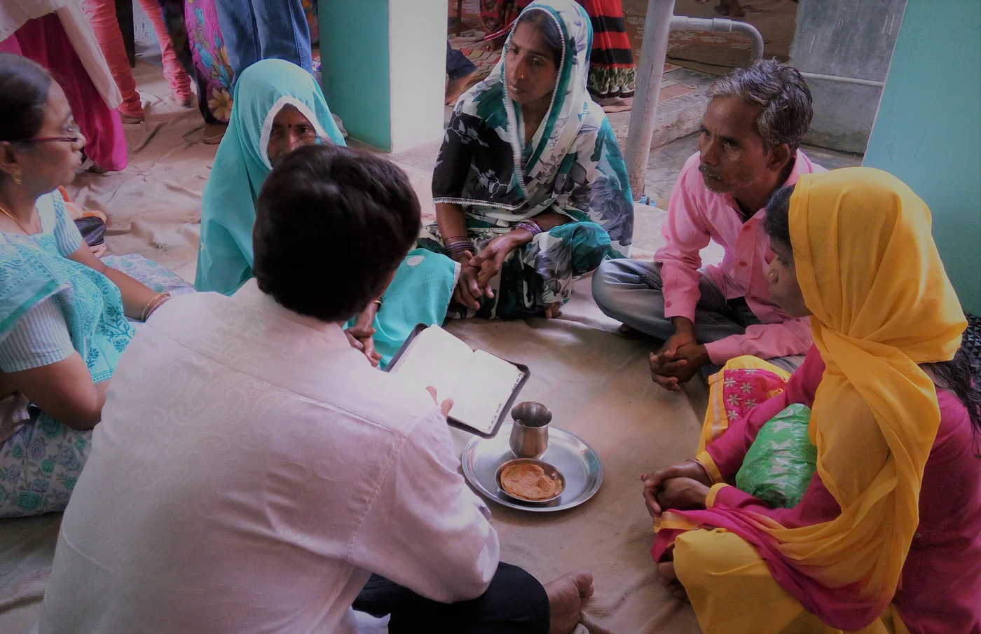 A small group seated in a circle on the floor, studying together